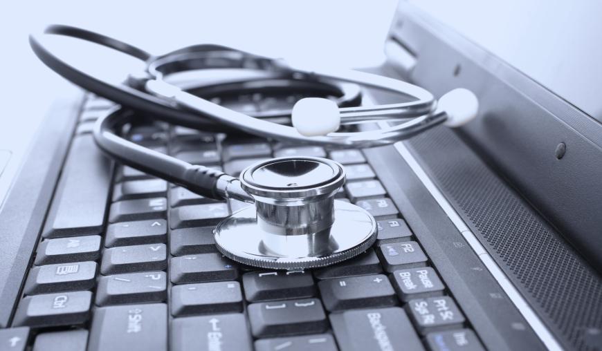 Laptop, auf dem ein Stethoskop liegt